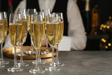 Glasses of champagne and waiter in restaurant. Space for text