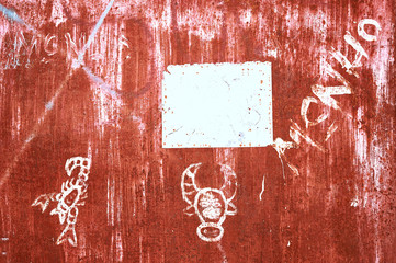 Close-up of children's scribbles and writings on a rust color painted metal Gate in the Philippines. White field can be used as copy space.