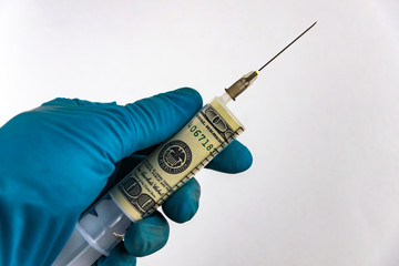 financial injections, money entry: a banknote of $ 100 inside a syringe for injections, in the...