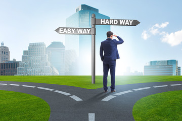 Businessman choosing between hard and easy way
