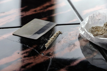 strip of cocaine on a background of packing with a drug and a plastic card