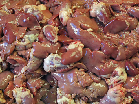 a pile of raw kidneys at a food market