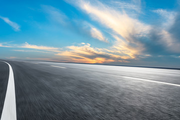 Fototapeta premium Motion blurred asphalt road ground and sky sunset clouds