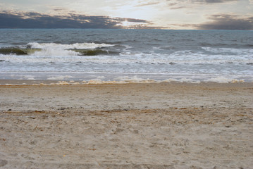 Cloudy Sunset on a Beach with Breaking Waves 