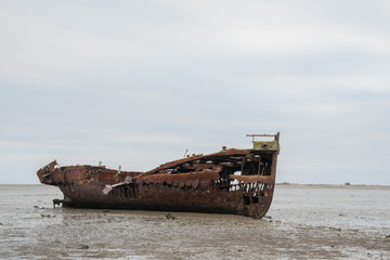 Abandoned shipwreck on the mud flats