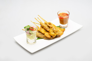 Satay pork with side dishes. With a white background