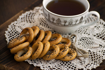 Bagels with cup of tea on a wooden board.