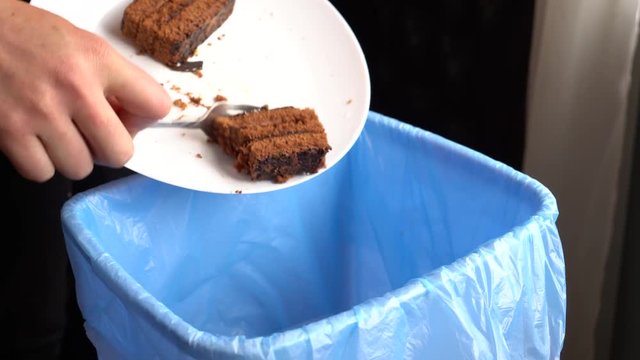 Female throwing the sweet bakery into garbage bin. Food Waste and The Environment. Healthy diet