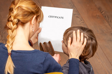 Mother comforting son despite the bad school certificate - Translation: certificate day of birth...