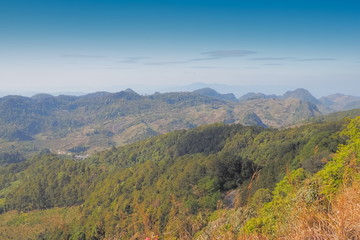 Mountain view morning on top of Doi Ang Khang above many hills and green forest cover with soft mist and blue sky background, Doi Angkhang, Chiang Mai, northern of Thailand.