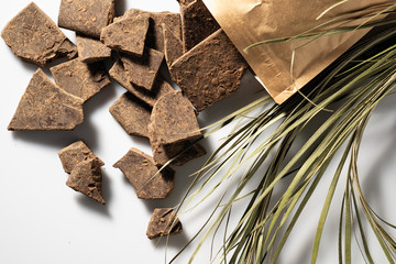 Natural chocolate without sugar from grated cocoa beans, in eco packaging on a light background