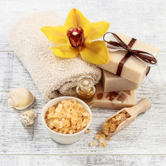 Fototapeta na wymiar Spa set with cosmetics, towels and beautiful yellow orchid flower.