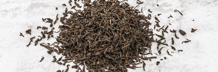 Dried tea is piled on a marble table.