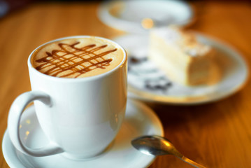 a piece of napoleon cake on a white plate with a cup of coffee