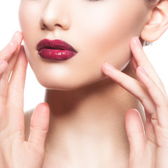 Close-up red lips, oman part of face, clean skin, hands touching cheek. Facial treatment concept