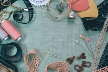 Sewing scene table flat lay composition. Threads, lace, pins, scissors, tape, reel, cloth. Pastel colors linen fabric text space. Top view banner template