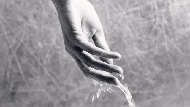 Water drains from the woman's hand. Water drains from the hand. Psychological problems concept. Hand close-up. Black and white.