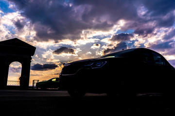 Fototapeta na wymiar car silhouette on evening sky during the sunset b