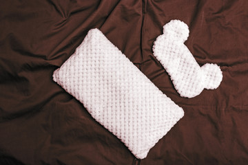 Soft pillow and sleep mask on dark crumpled sheet. Top  view. Flat lay.