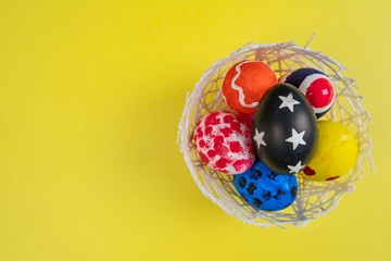 easter eggs on yellow background in flat lay with copy space