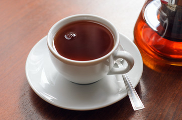 White cup of tea on a wooden table. Tea party concept, break.