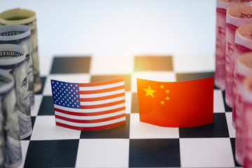 USA dollar and China Yuan banknote  on chess table. Its is symbol for tariff trade war crisis or...