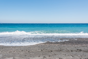 Fototapeta na wymiar Waves Washing Ashore on a Black Sand Volcanic Beach in Sicily