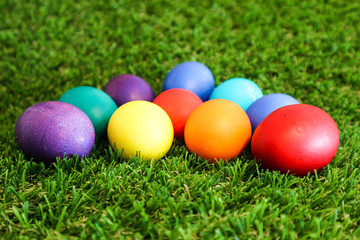 Beautiful bright colorful easter eggs in green grass closeup