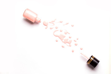 Nail polish bottle and drops on white background