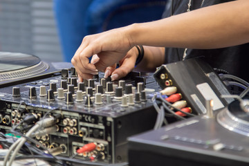 female hands playing DJ mixer