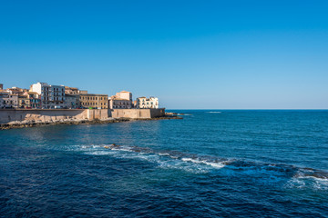 Fototapeta na wymiar View of the Still Mediterranean Sea and Syracuse, Sicily, Italy