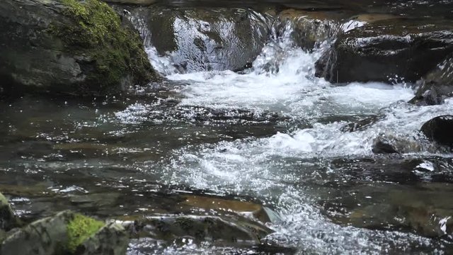 Fast rushing white water stream in slow motion