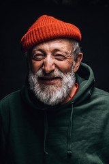 Close up portrait of happy 70-year-old optimist man with smiling wrinkled face, dressed in hipster...