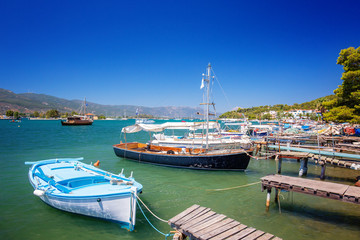 Poros island in a summer day in Greece. Wooden pier with fishing boats at Poros island in Greece