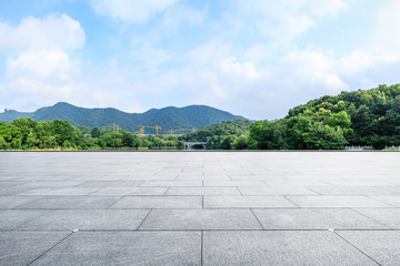 Empty square floor and green mountain with sky landscape