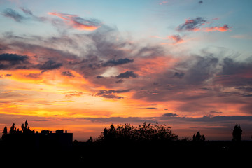 Obraz premium Beautiful dramatic sunset on the background of the silhouette of the evening city