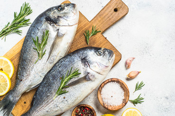 Raw dorado fish on cutting board on the table.