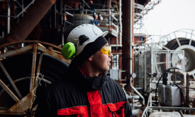 Worker in workwear, protective helmet and goggles working