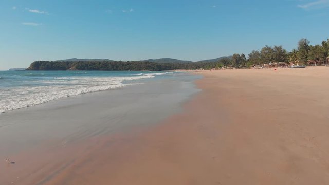 Low drone flight over the waves of Agonda beach. Goa State. India.
