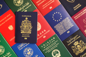 Blue biometric passport of Canada on a blurred background of passports of many countries of the...