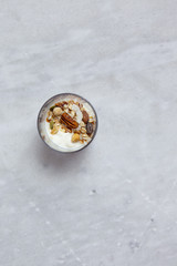 Obraz na płótnie Canvas Granola with yogurt, honey and chocolate bars on marble table with copy space
