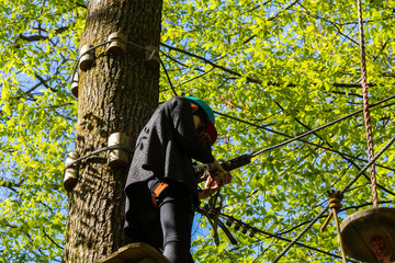 Parcours d'Accrobranche en forêt avec personne en action