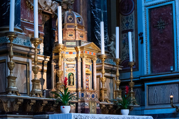 Rich candlesticks on colorful catholic altar
