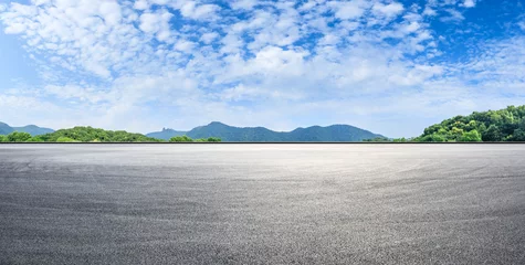  Asphalt race track ground and mountains with blue sky landscape © ABCDstock