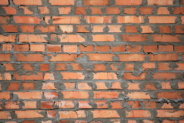The red brick wall texture. The fragment of a new bricklaying. The construction of a new multistory building. The construction site
