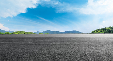 Empty asphalt road ground and mountains with blue sky on a sunny day