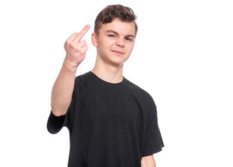 Naklejka premium Handsome Angry Teen Boy in black T-shirt showing the Middle Fingers. Portrait of caucasian sad child making bad Gesture and looking at camera, isolated on white background.