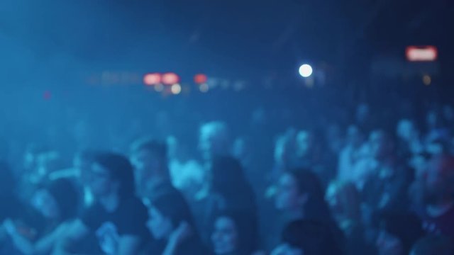 Fans enjoying the performance of their favorite rock band. Audience at a rock concet in front of the stage.