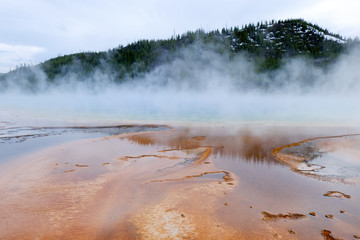 colorful geothermal pool with mountain background in yellowstone (Grand Prismatic Spring)