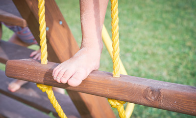 Child on monkey bars. Kid at beach playground. Little boy hanging on gym activity center of preschool play ground. Healthy outdoor activity for kids. Sport for young children.